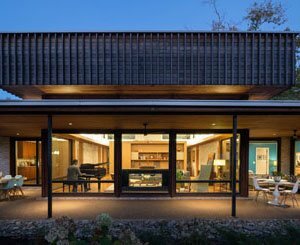 A 50s brick house reinvents itself with the cropping and siding of its 'hat' roof, which overlooks the central living space