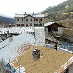 Two-material thermo-acoustic sarking insulating sheet for sloping roofs in mountain climates